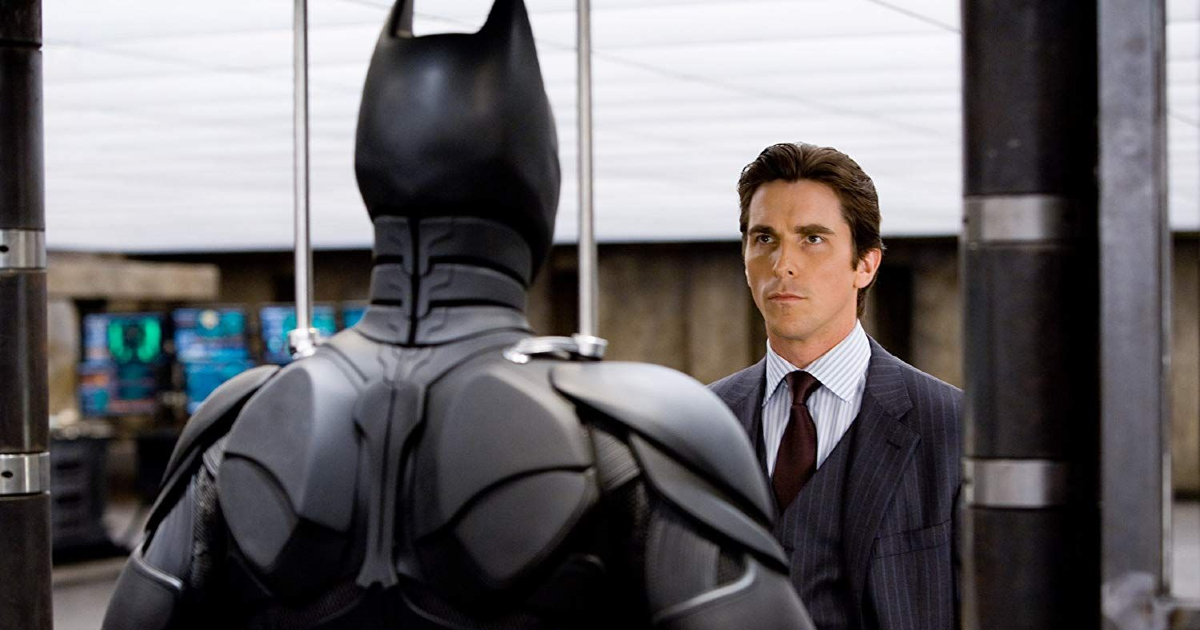 nel cavaliere oscuro bruce wayne osserva il suo costume da batman - nerdface