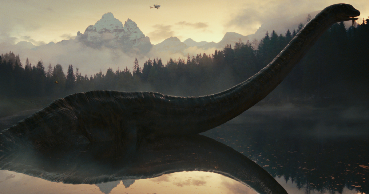 un enorme dinosauro emerge da un lago in jurassic world il dominio - nerdface