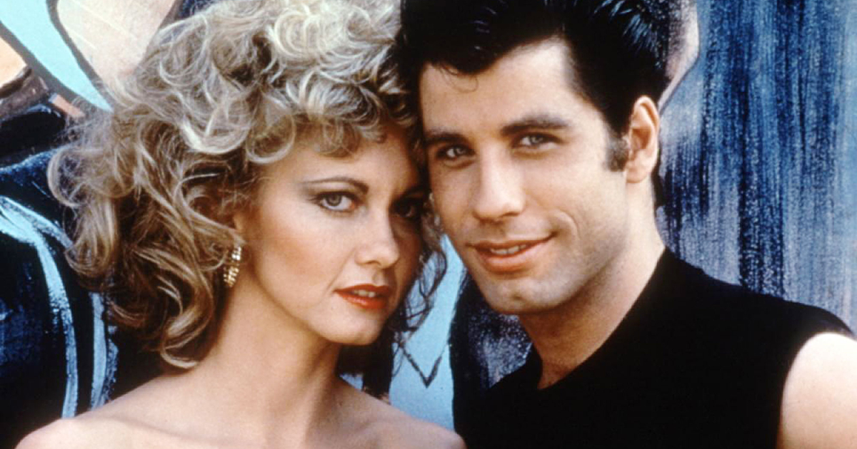 i due protagonisti di grease sono poggiati tempia su tempia - nerdface