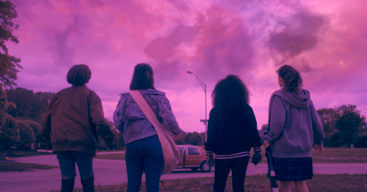 le quattro ragazze di paper girls davanti a un cielo rosa - nerdface