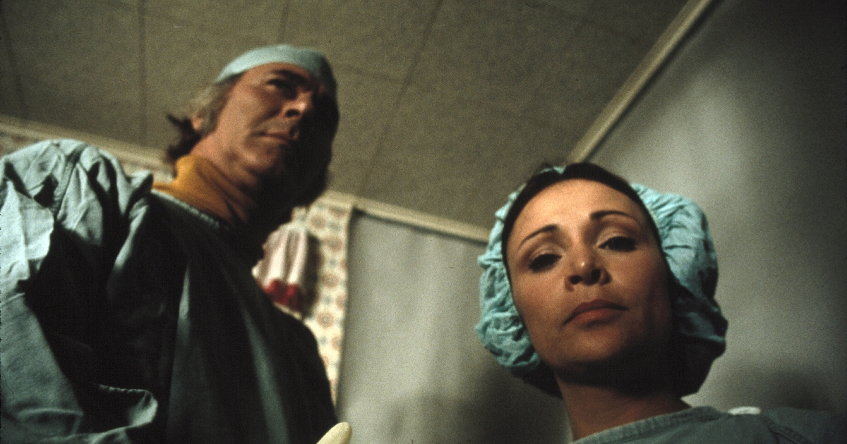un uomo e una donna vestiti da chirurghi stanno per torturare qualcuno - nerdface