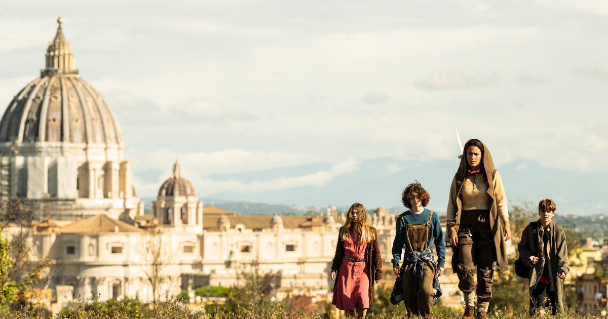 i quattro ragazzi camminano con san pietro sullo sfondo ne i viaggiatori - nerdface