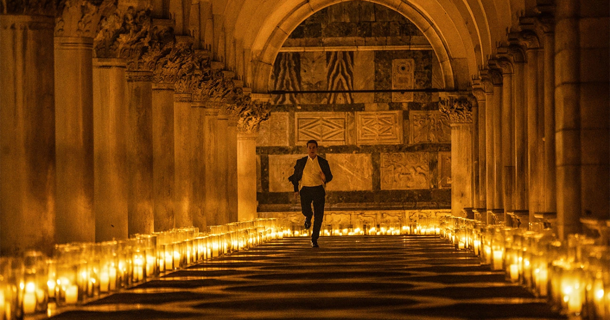 tom cruise in una chiesa illuminata da candele in mission impossible dead reckoning - nerdface