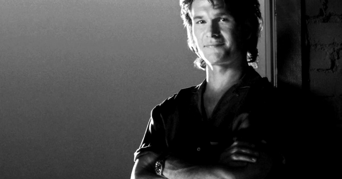 patrick swayze sorride poggiato a una porta - nerdface