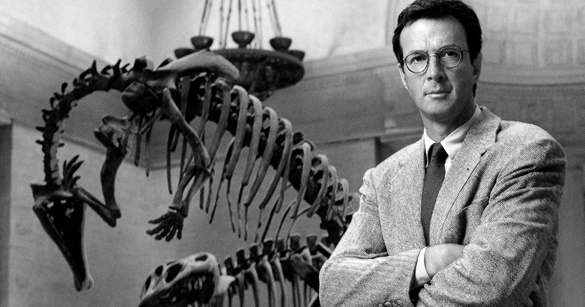 michael crichton in posa davanti uno scheletro di dinosauro - nerdface