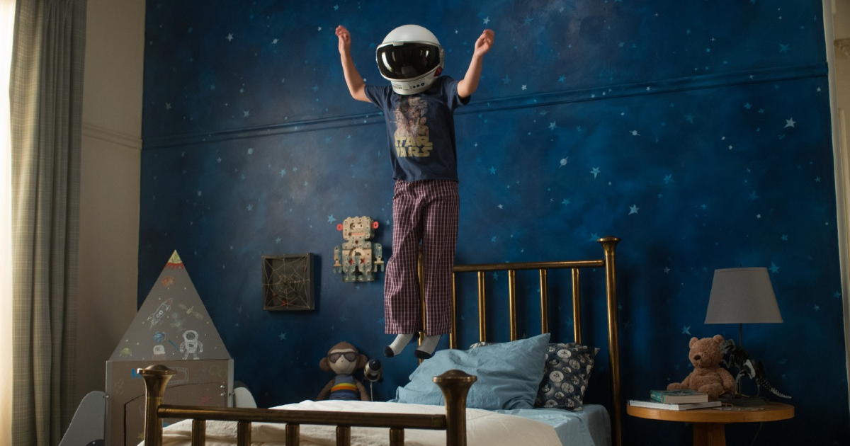 il bambino protagonista di wonder salta sul letto indossando un casco d'astronauta - nerdface