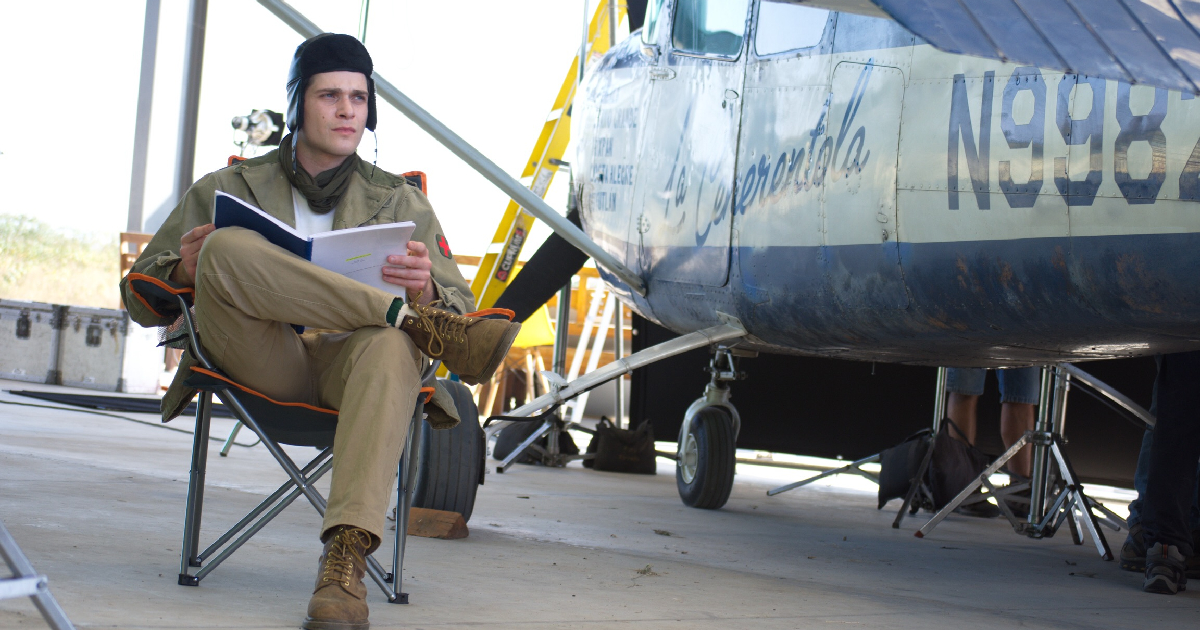 un uomo è seduto a leggere accanto a un piccolo aeroplano in un messicano sulla luna - nerdface