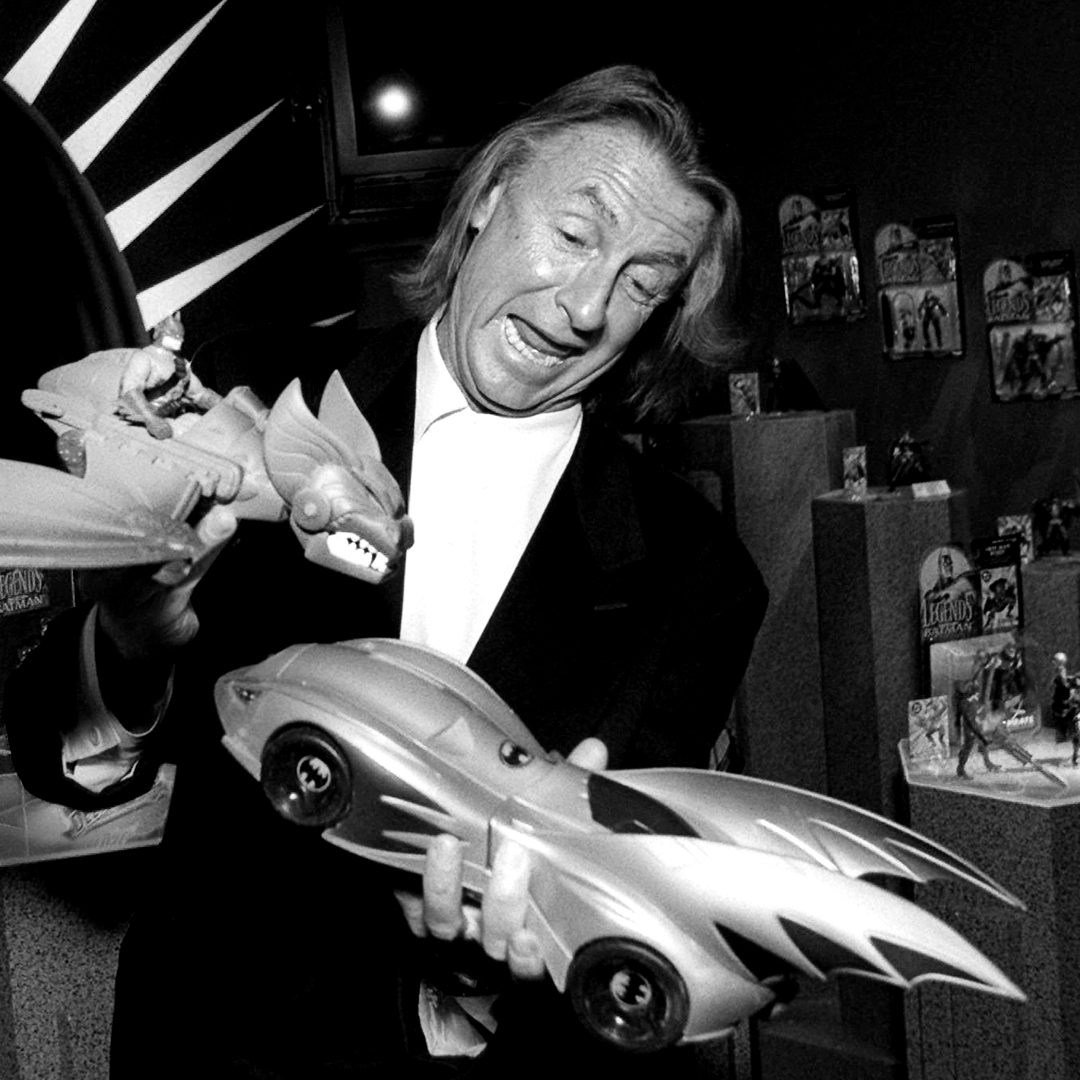 joel schumacher gioca con un aereo pipistrello e una batmobile giocattolo - nerdface