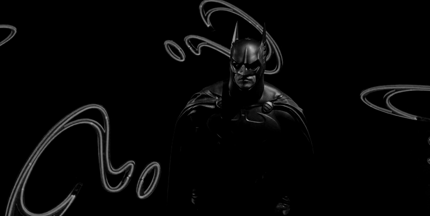 batman con sullo sfondo i punti interrogativi dell'enigmista in uno dei film di joel schumacher - nerdface