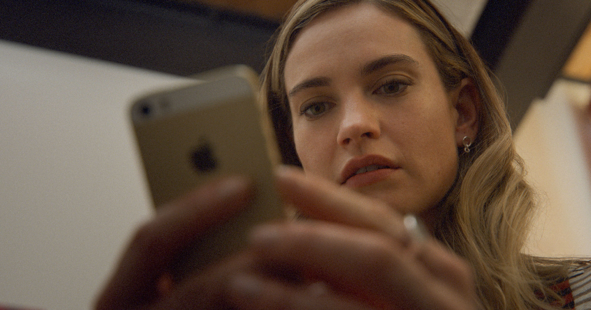 lily james guarda qualcosa al cellulare in swiped - nerdface