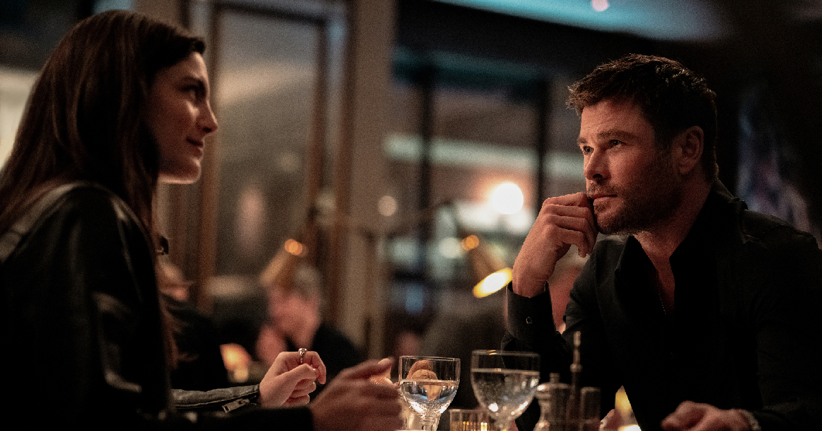 chris hemsworth osserva una squinzia al tavolo in crime 101 - nerdface