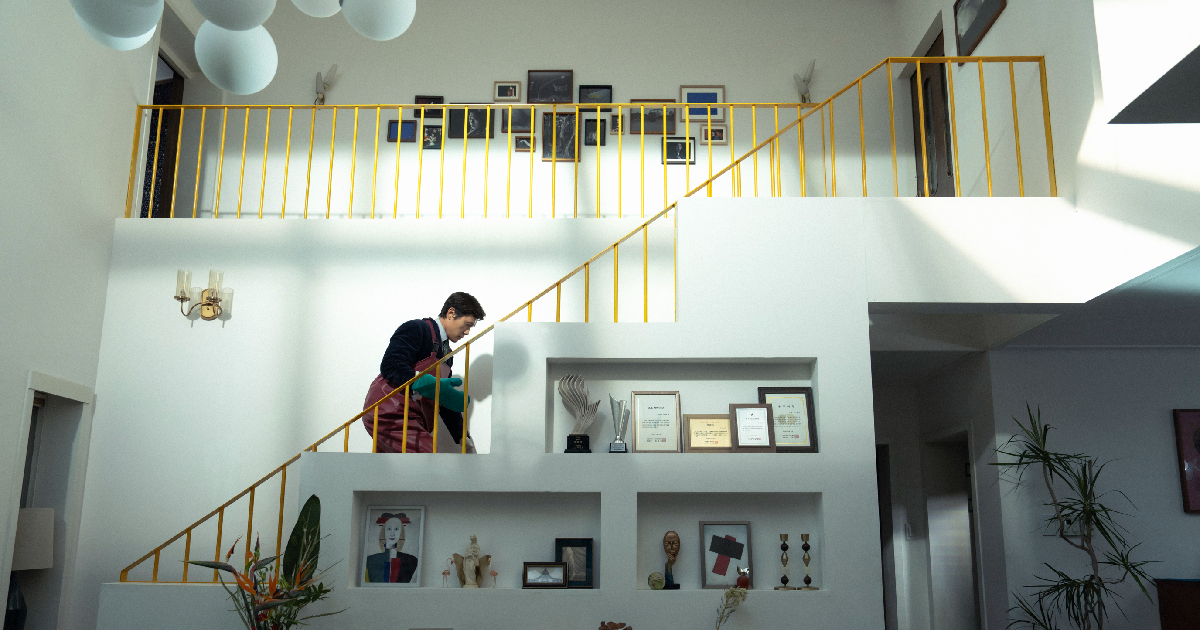 il protagonista di no other choice pulisce qualcosa dalle scale di una casa - nerdface