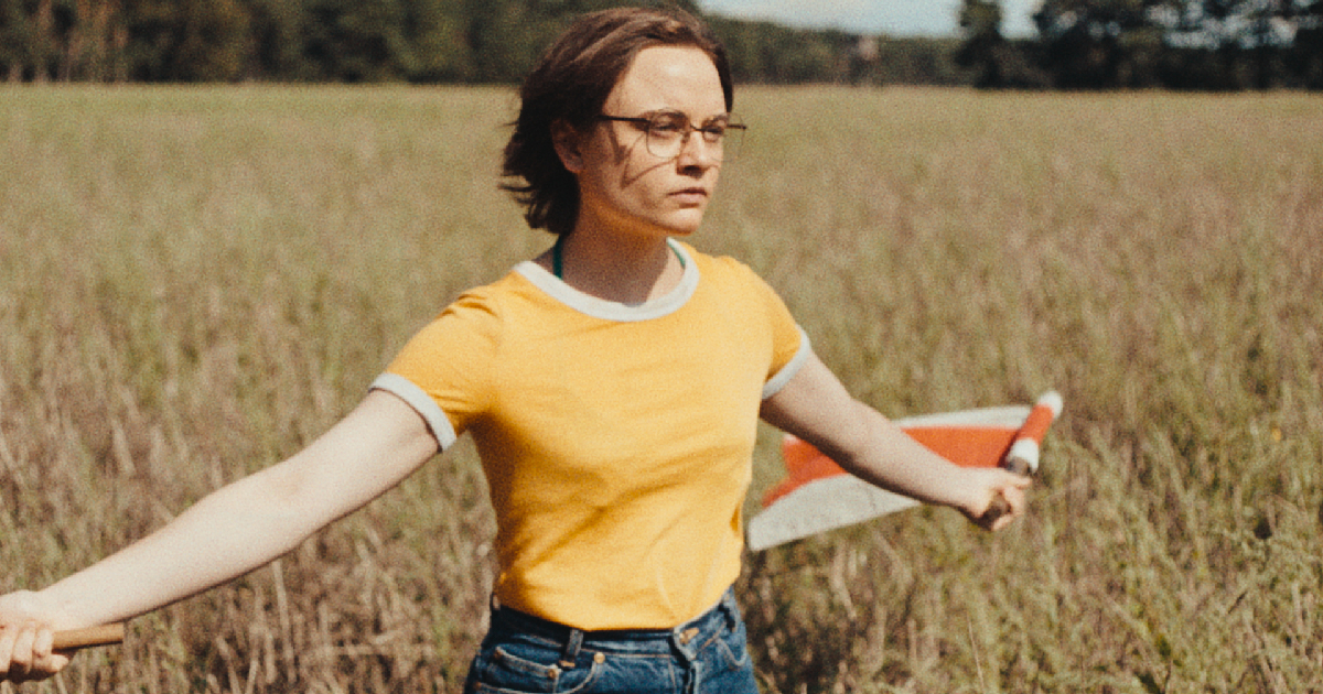 una donna apre le braccia in un prato ne il suono di una caduta - nerdface
