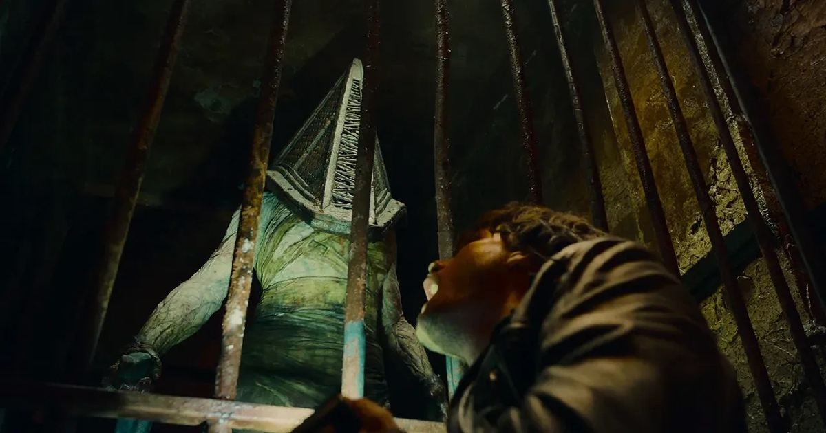 il classico cattivone di return to silent hill con la testa metallica a piramide minaccia il protagonista del film da una cella - nerdface
