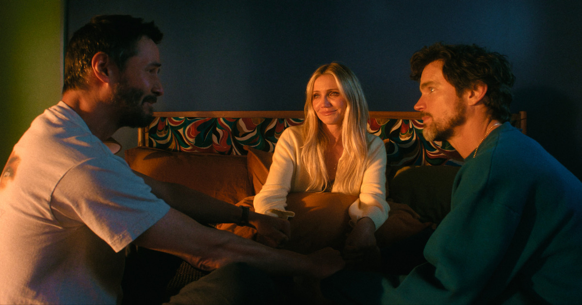 Il protagonista con altre due persone stanno sedute in cerchio sul letto tenendosi per mano - nerdface