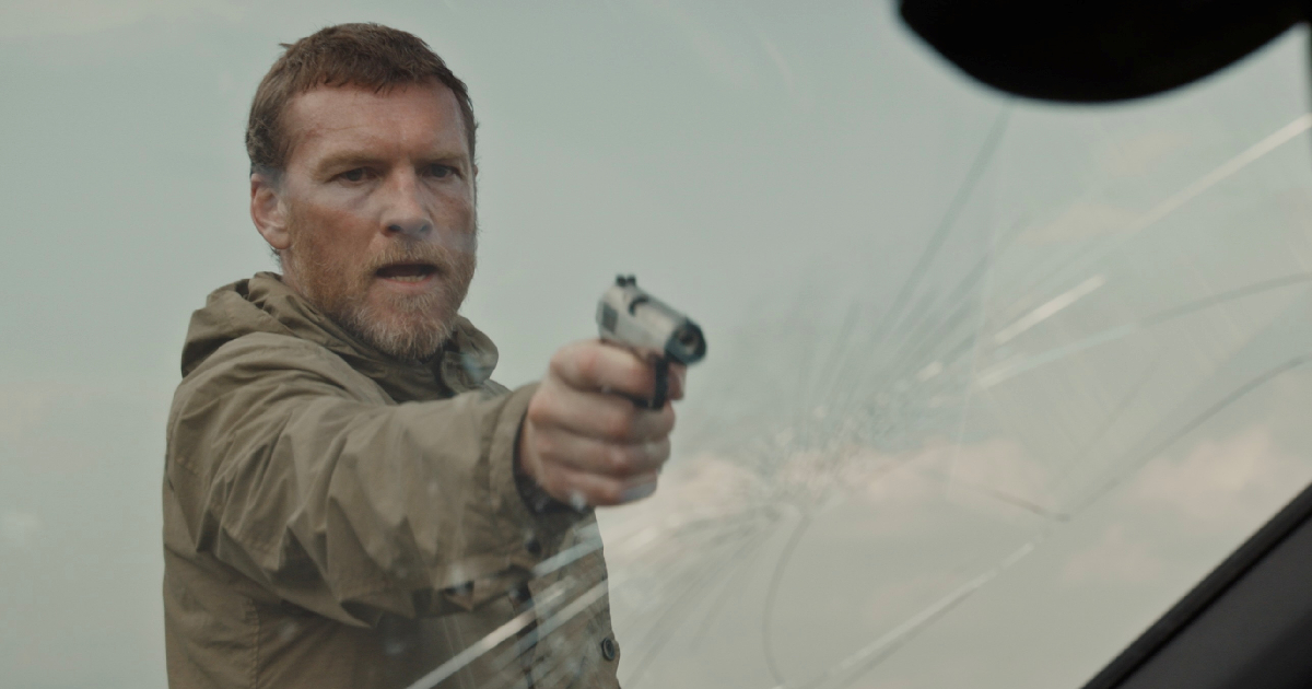 sam worthington punta una pistola contro qualcuno nel film fuze - nerdface
