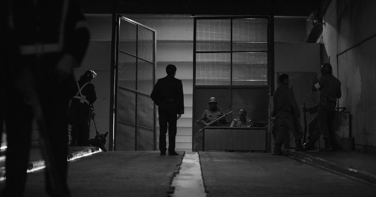 un uomo entra in una sala torture nel trailer del film l'hangar rosso - nerdface