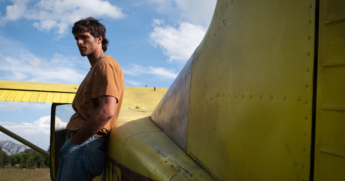jacob elordi poggiato su un biplano giallo nel film the dog stars - nerdface