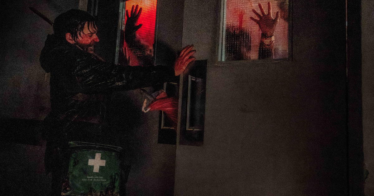 resident-evil-tra-orrore-e-comicita-recensione il protagonista di resident evil chiude fuori da una porta un'orda di zombie - nerdface